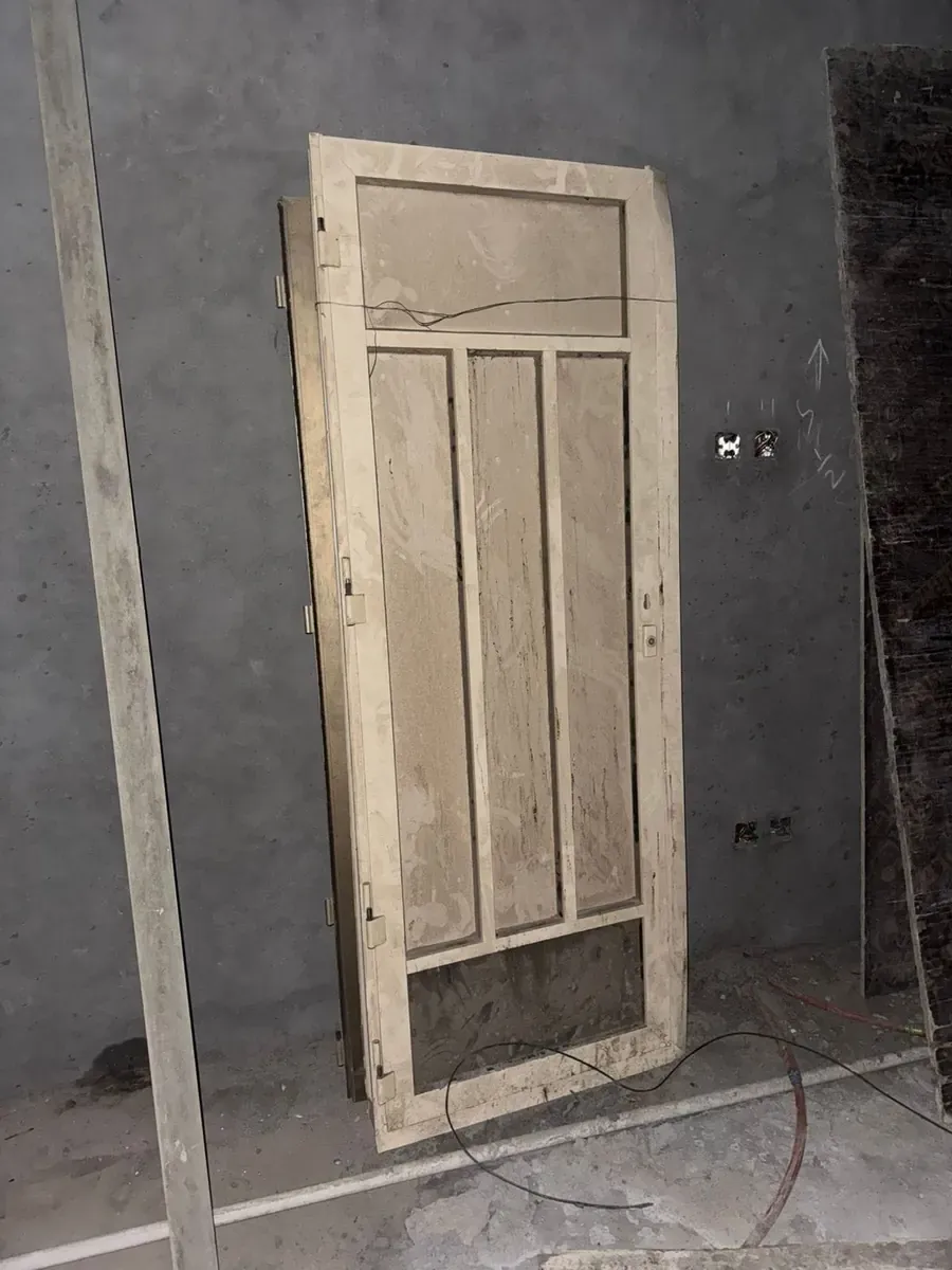 باب قديم مسند إلى جدار داخل غرفة مجردة
